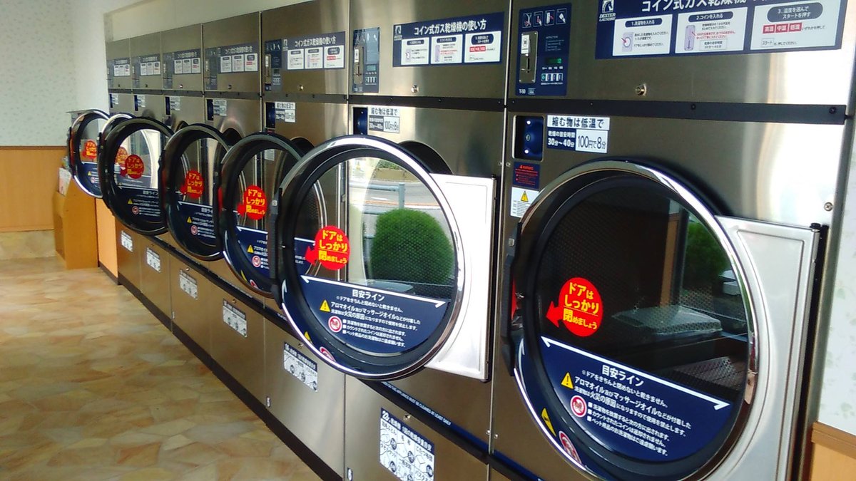 マンマチャオ鎌ヶ谷東道野辺店のガス乾燥機。各機の上部に「コイン式ガス乾燥機の使い方」と温度設定の案内が掲示されている